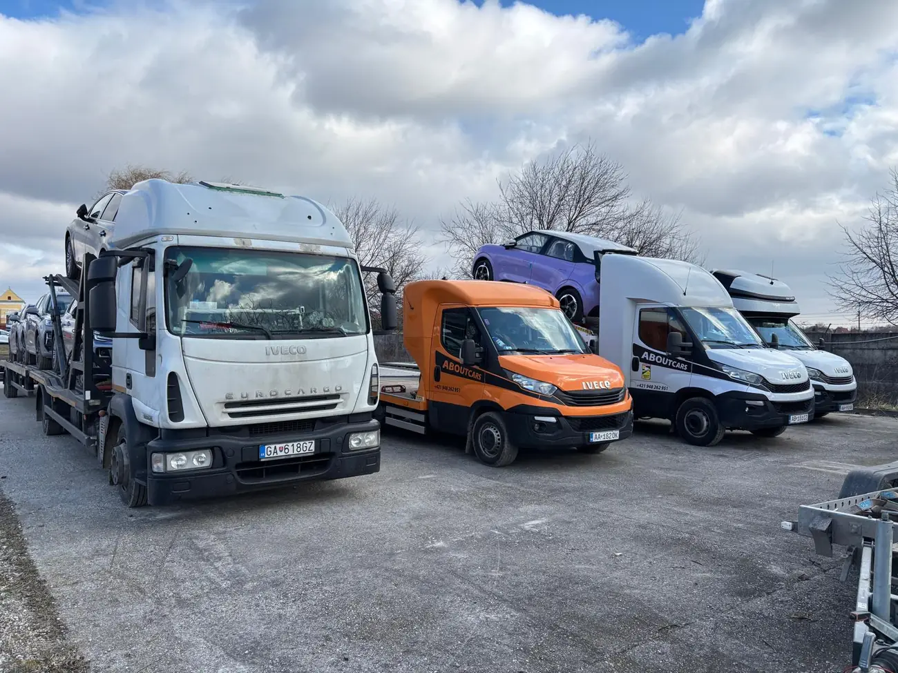 Vozový park AboutCars — autoprepravníky a dodávky na parkovisku